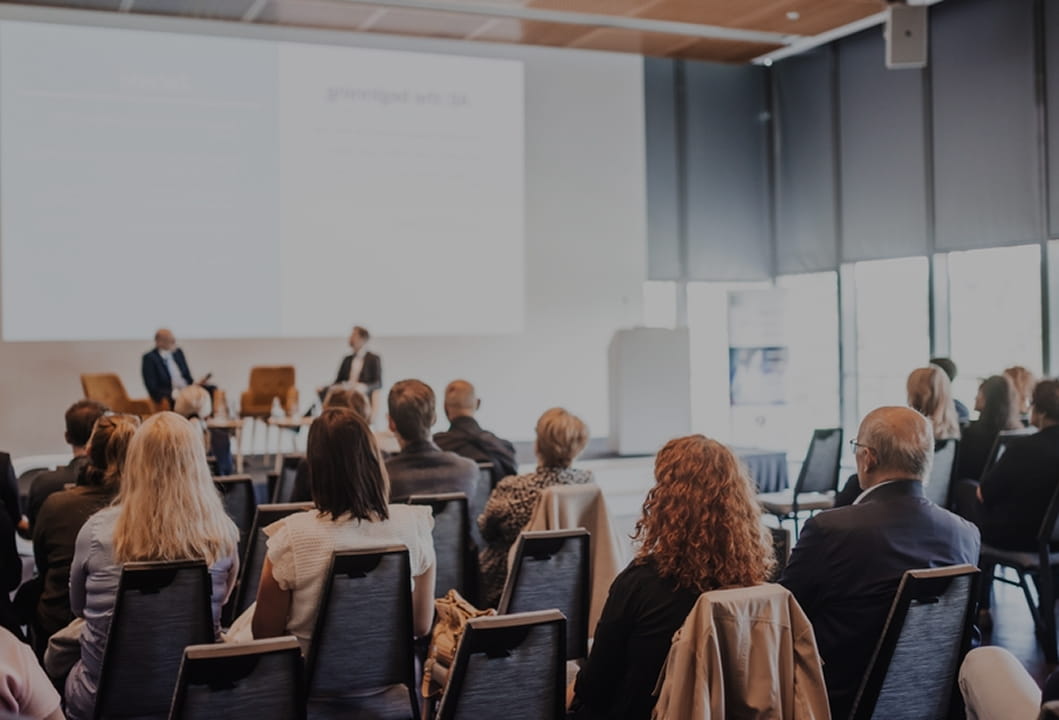 classroom presentation with seated attendees and front-of-room display technology 