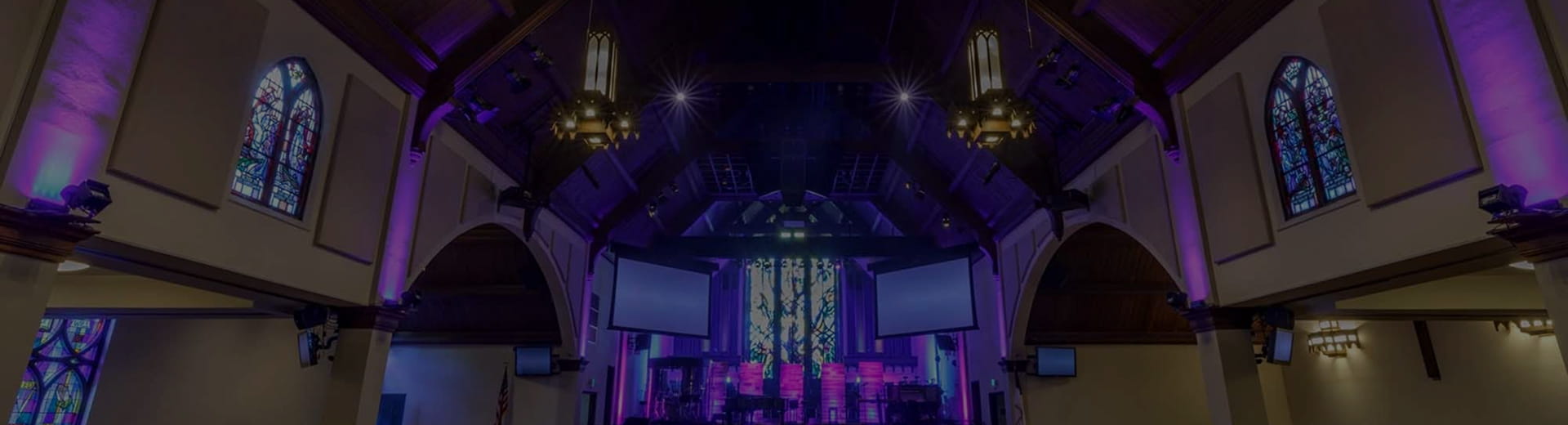 house of worship sanctuary with stained glass and warm architectural lighting
