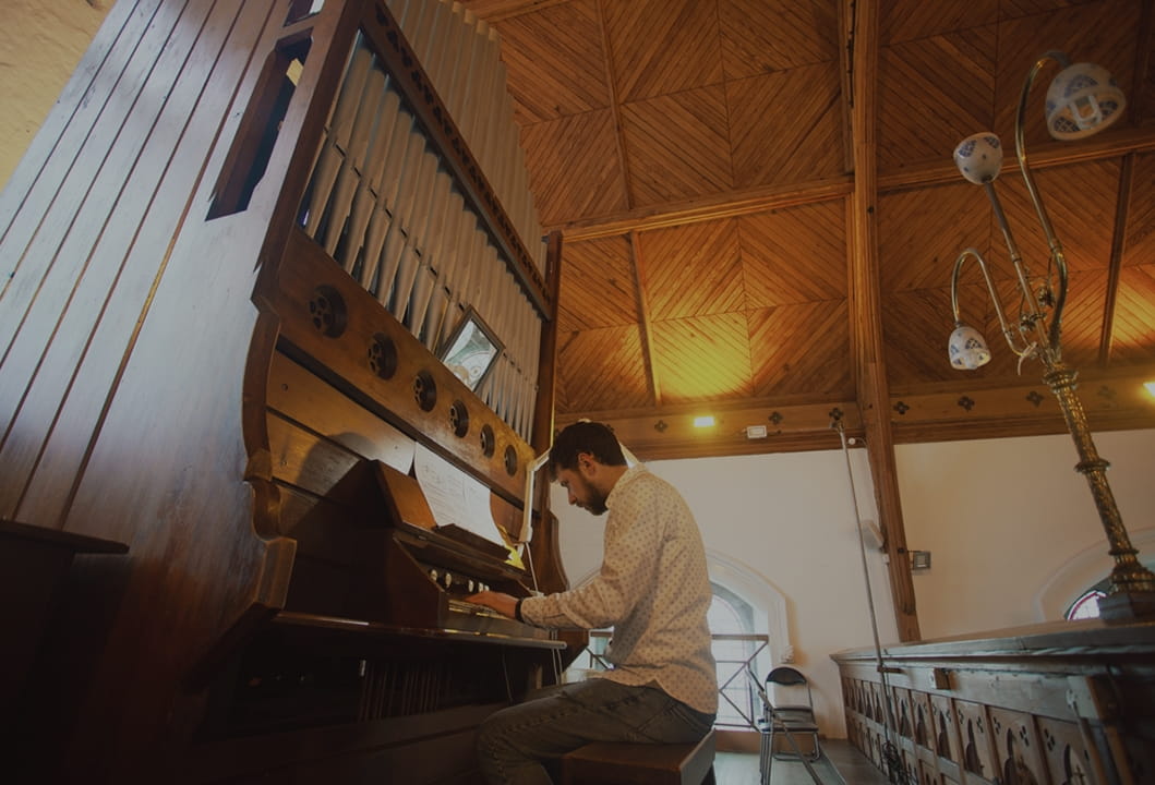 musician playing organ inside a historic house of worship
