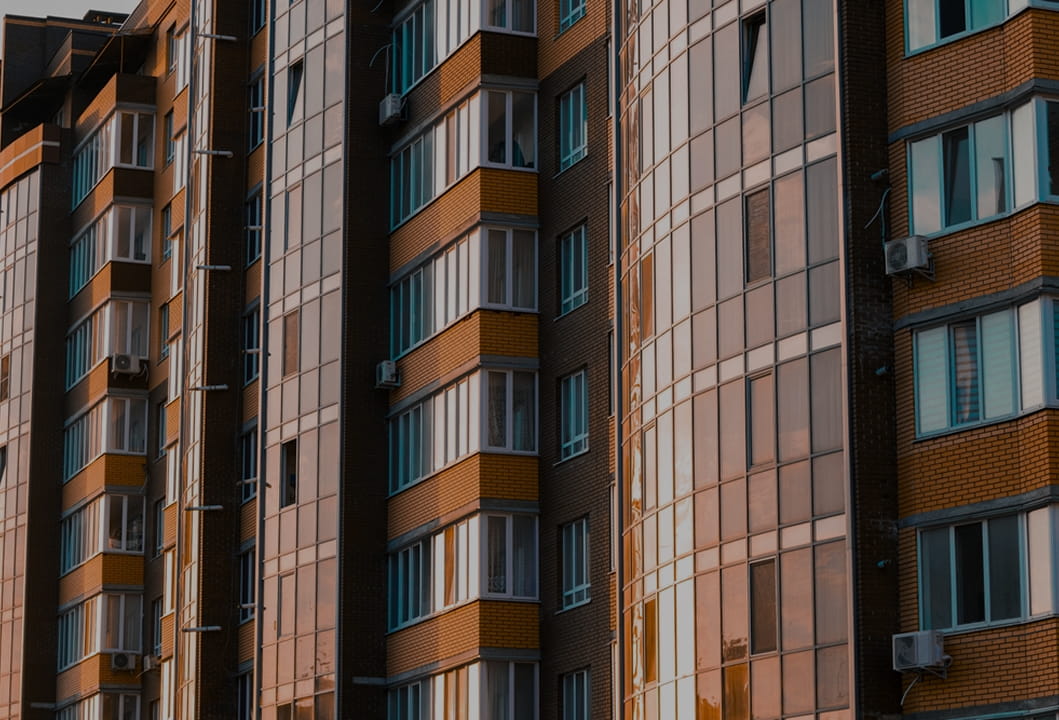 close-up of multi-family apartment exterior with balconies and warm window lighting